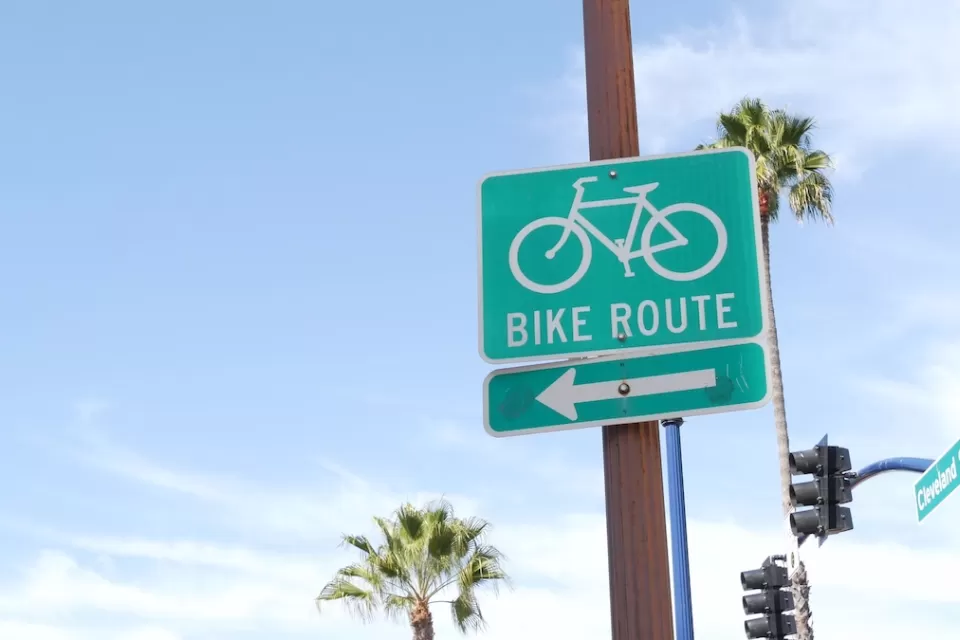 Close-up of green and white Bike Route sign with arrow in California.